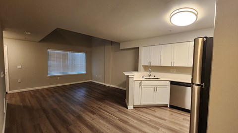 A kitchen with white cabinets and a black refrigerator.